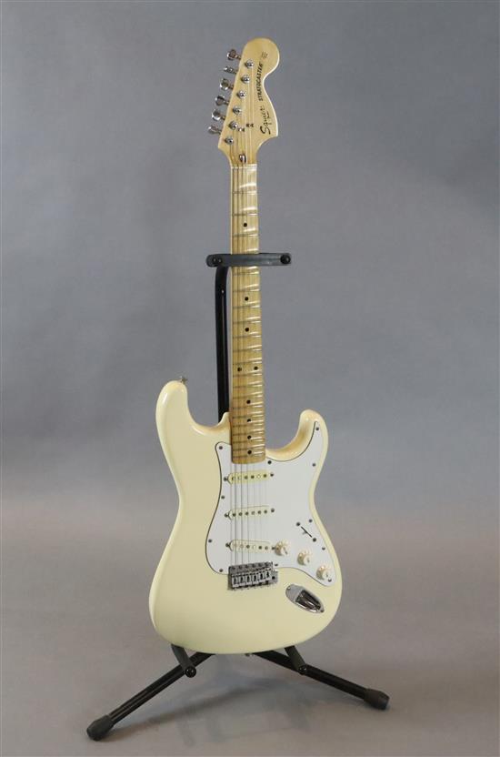 A Squire Fender Stratocaster electric guitar, scallop neck, cream and white with soft case